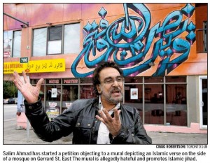 Salim Ahmad of the Muslim Canadian Congress who has initiated a petition to Mayor Rob Ford of Toronto asking that the jihadi mural behind him in this picture, be removed.